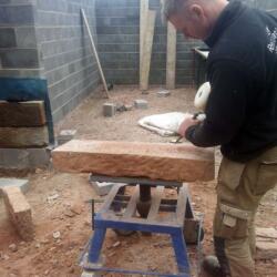 hand cutting stone for cedar clad garage